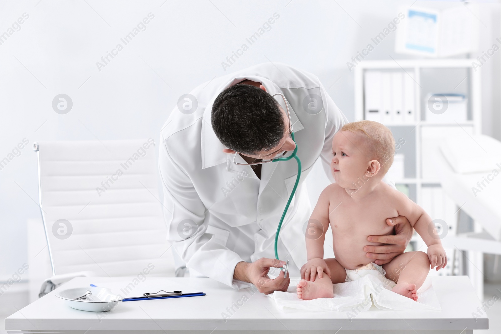 Photo of Children's doctor examining baby with stethoscope in hospital