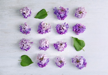 Flat lay composition with beautiful blossoming lilac on light background. Spring flowers