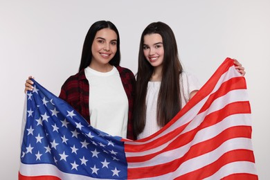 Photo of 4th of July - Independence Day of USA. Happy woman and her daughter with American flag on white background