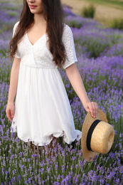 Young woman with straw hat in lavender field, closeup