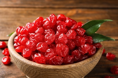 Bowl with tasty cherries on wooden background, closeup. Dried fruits as healthy food