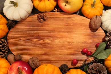 Thanksgiving day. Flat lay composition with pumpkins and wooden board on table, space for text