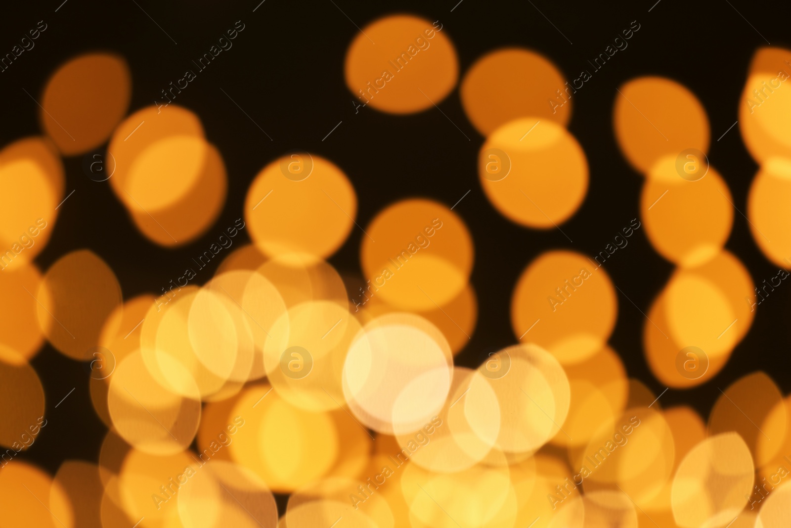 Photo of Beautiful golden lights on dark background. Bokeh effect