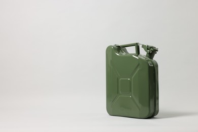 Photo of Green metal canister on light grey background, space for text