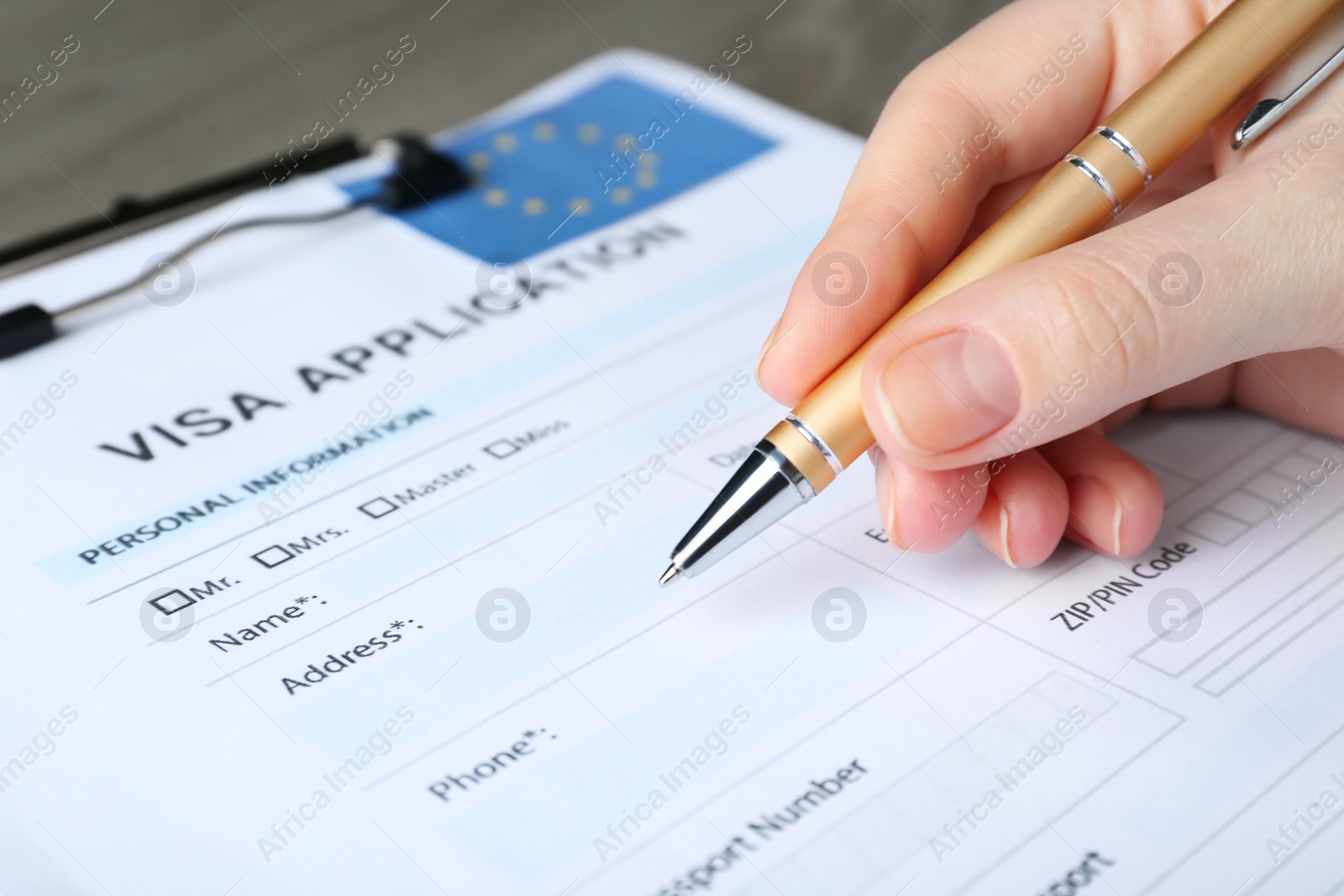 Photo of Woman filling visa application form for immigration to European Union at table, closeup