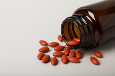 Photo of Bottle with pills on light background, closeup and space for text. Anemia treatment