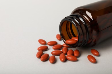 Bottle with pills on light background, closeup and space for text. Anemia treatment