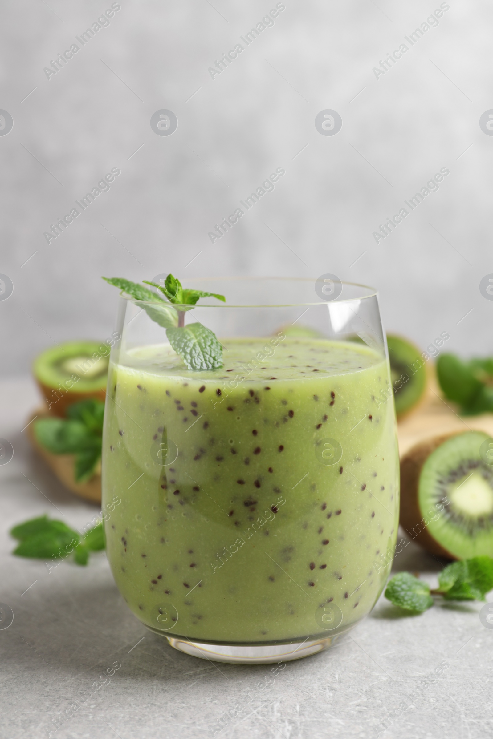 Photo of Delicious kiwi smoothie on light grey table