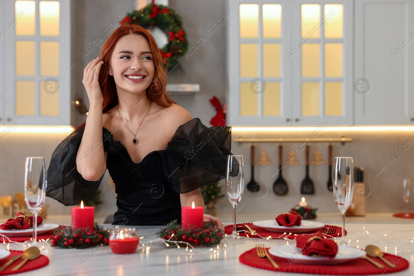 Photo of Beautiful young woman at table served for Christmas in kitchen