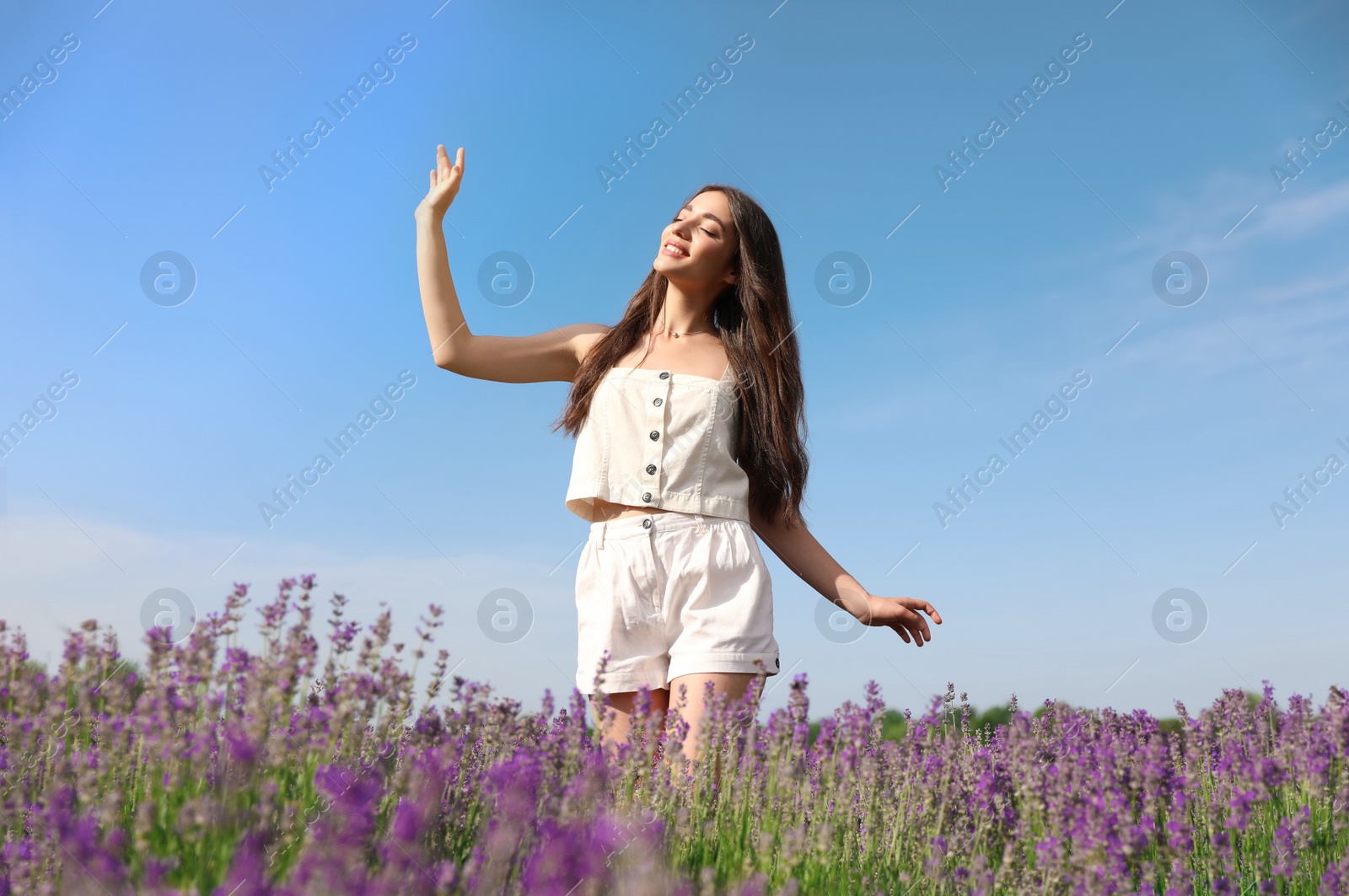 Photo of Young woman in lavender field on summer day