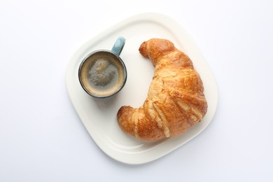 Delicious fresh croissant and cup of coffee on white background, top view