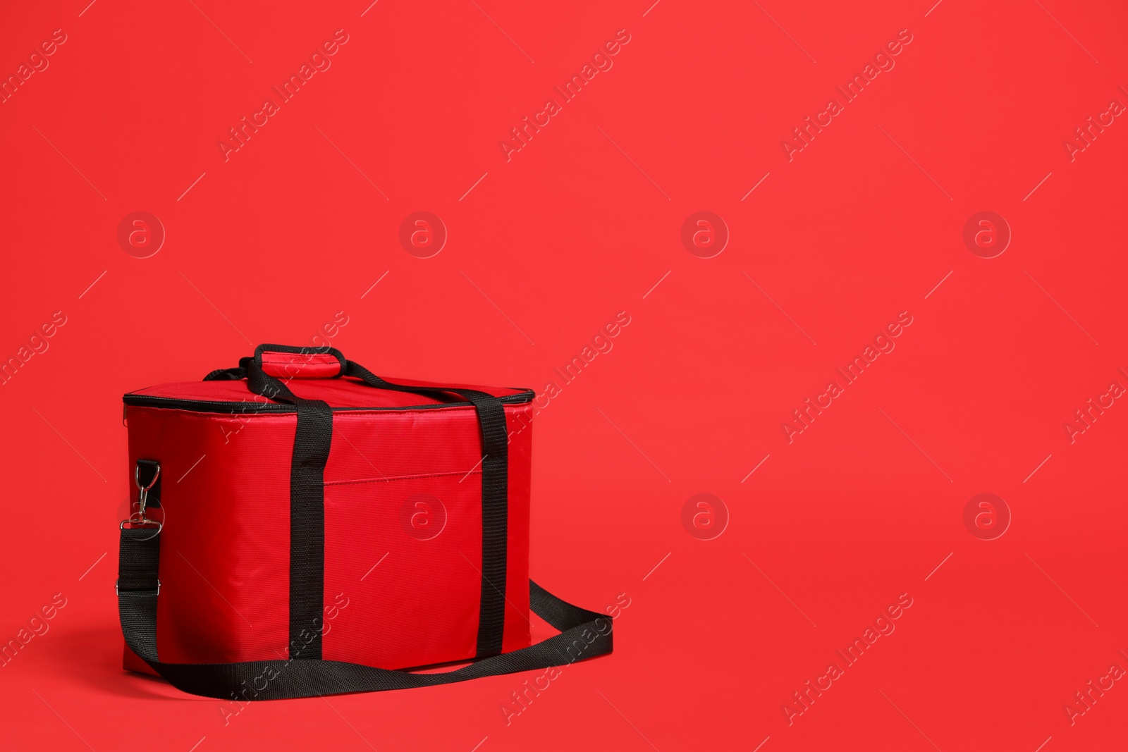 Photo of Modern large thermo bag on red background. Space for text