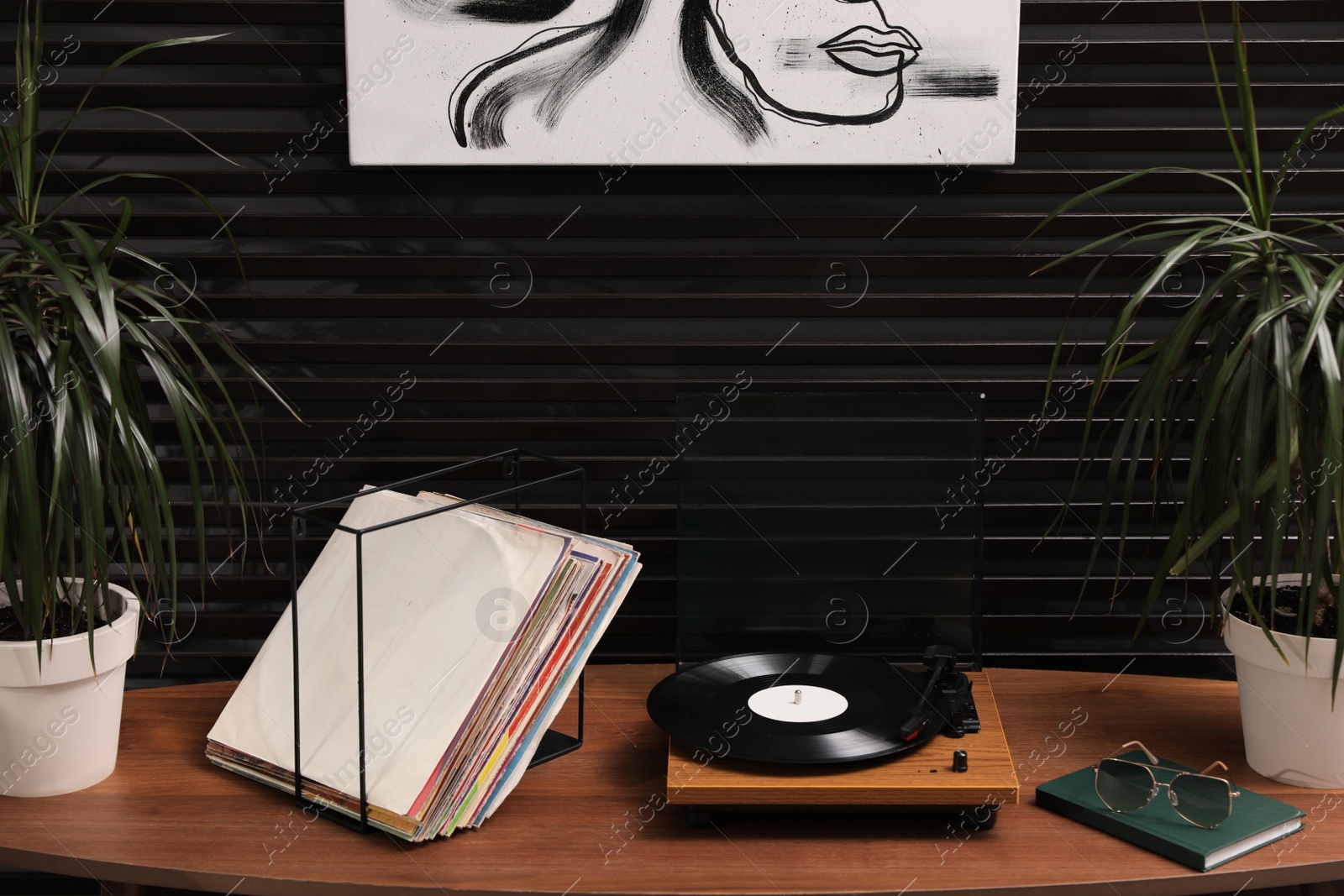 Photo of Stylish turntable with vinyl discs on table in room