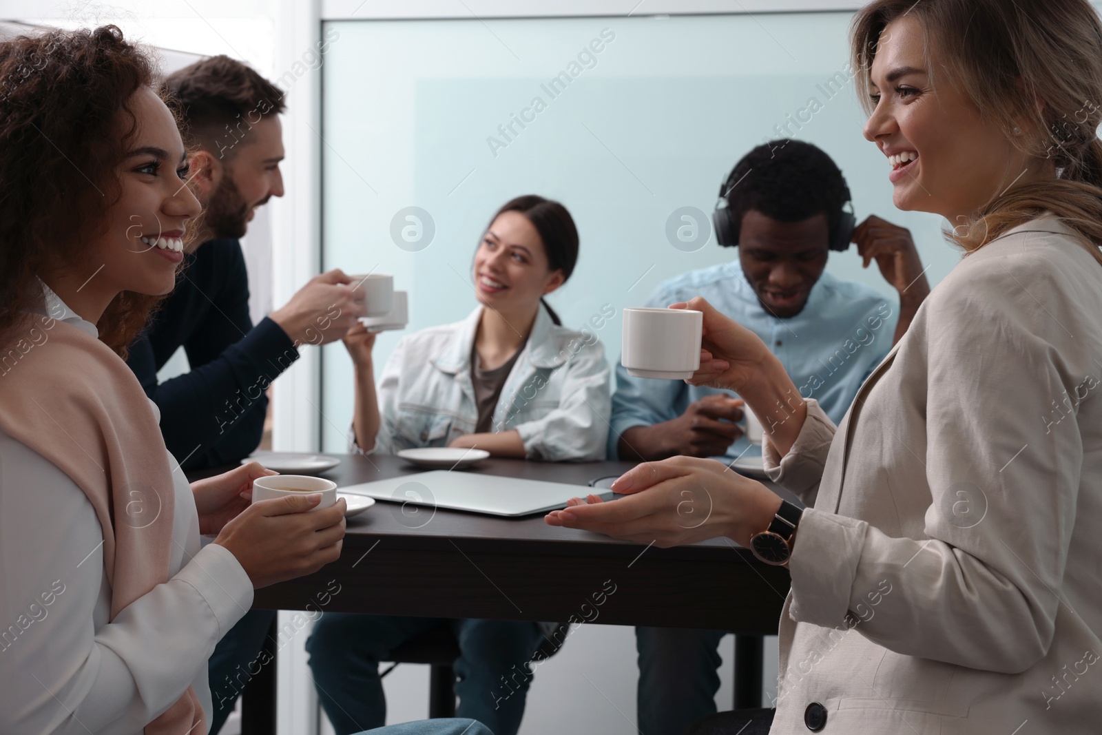 Photo of Team of employees enjoying coffee break together in office. Startup project