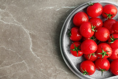 Photo of Plates with fresh ripe tomatoes on grey background, top view