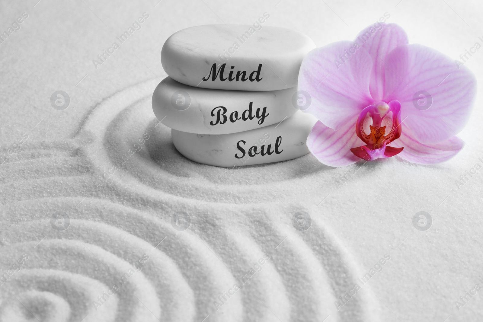 Image of Stones with words Mind, Body, Soul and orchid on sand. Zen lifestyle