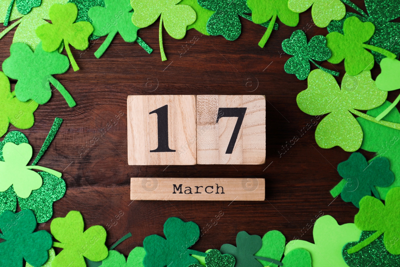 Photo of Flat lay composition with block calendar on wooden background. St. Patrick's Day celebration