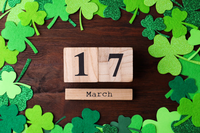 Photo of Flat lay composition with block calendar on wooden background. St. Patrick's Day celebration
