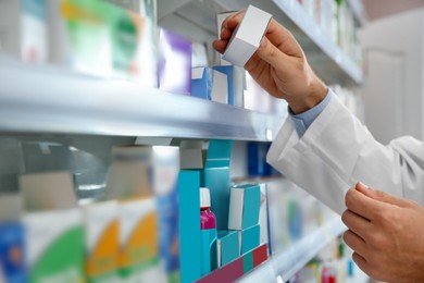 Photo of Professional pharmacist with medicine in modern drugstore, closeup