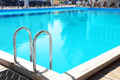 Photo of Modern swimming pool with step ladder outdoors