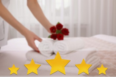 Image of Chambermaid putting flowers with fresh towels bed in five star hotel room, closeup, closeup