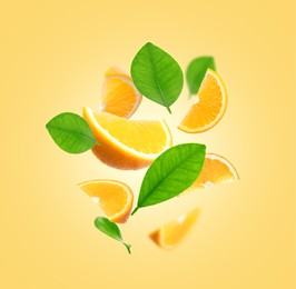 Image of Juicy orange slices and green leaves flying on pale golden background