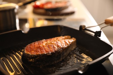 Photo of Frying pan with cooked salmon steak, closeup