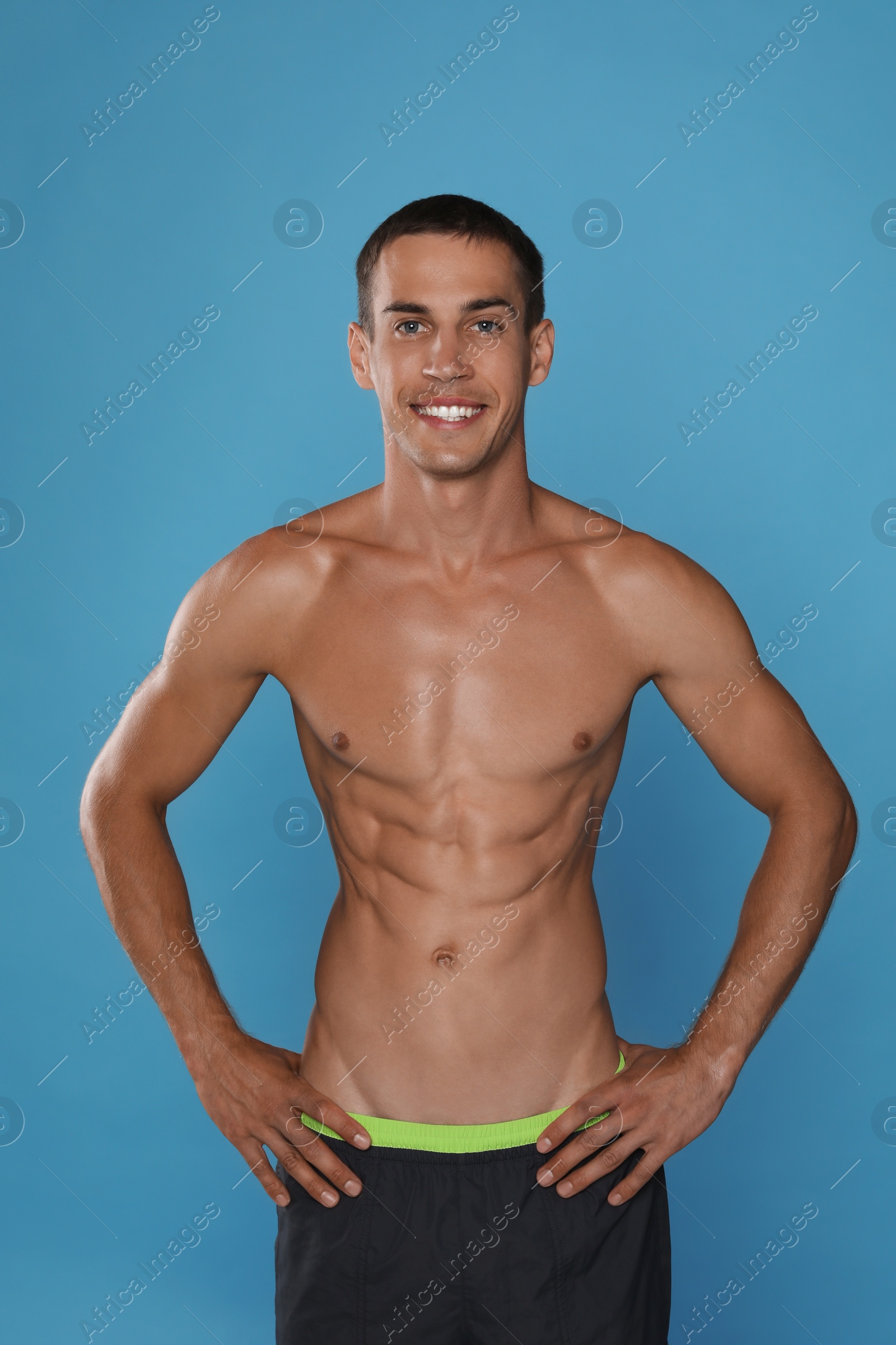 Photo of Handsome shirtless man with slim body on light blue background