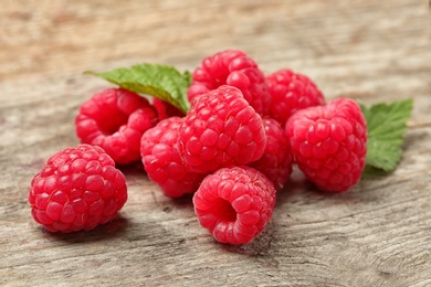 Photo of Ripe aromatic raspberries on wooden table