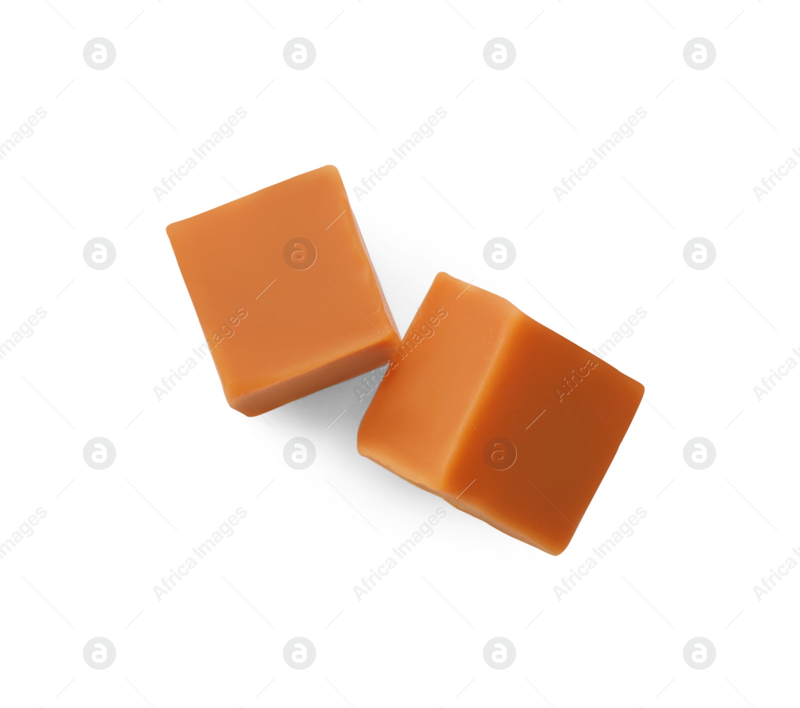 Photo of Two sweet caramel candies on white background, top view