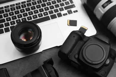 Photo of Professional photographer equipment and laptop on table