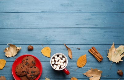 Photo of Flat lay composition with cup of hot drink on blue wooden table, space for text. Cozy autumn atmosphere