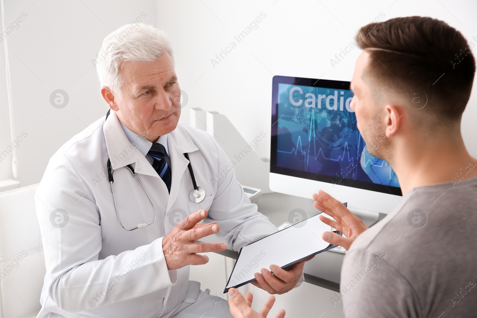 Photo of Male doctor working with patient in clinic. Cardiology consultation