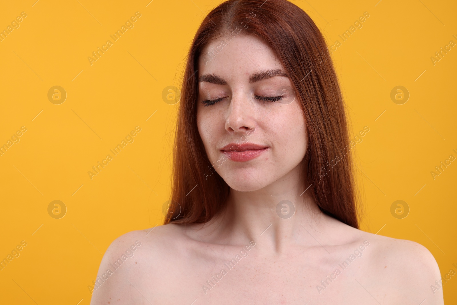 Photo of Portrait of beautiful woman with freckles on yellow background