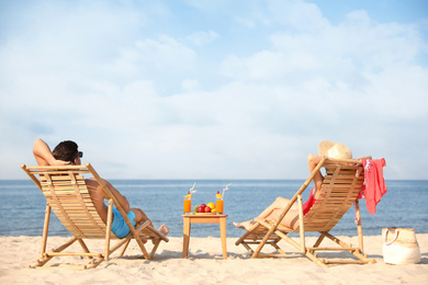 Photo of Couple resting on sunny beach at resort