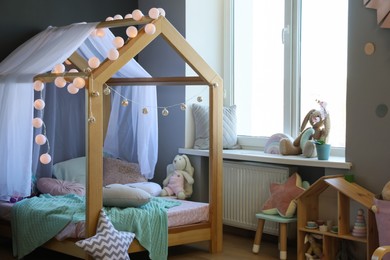 Stylish child room interior with house bed and different toys