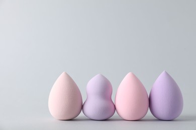 Photo of Many makeup sponges on light grey background