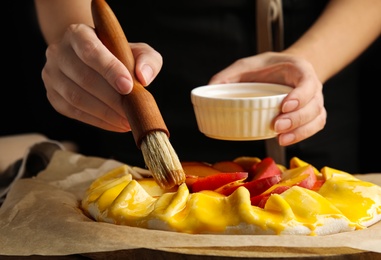 Woman making peach pie at table, closeup