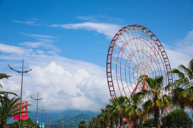 BATUMI, GEORGIA - JUNE 14, 2022: Beautiful landscape with Ferris wheel against cloudy sky