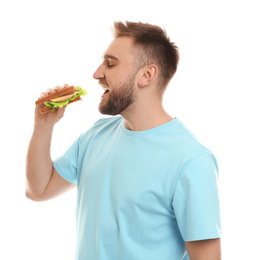 Photo of Young man eating tasty sandwich on white background