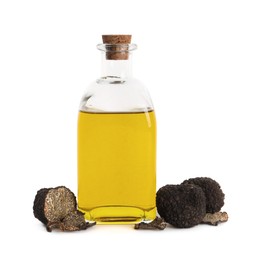 Photo of Glass bottle of oil and fresh truffles on white background