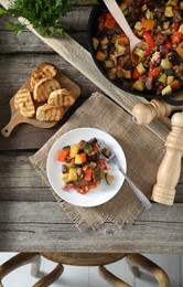 Delicious ratatouille served on wooden table, flat lay