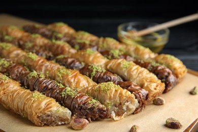 Photo of Delicious sweet baklava with pistachios on board, closeup