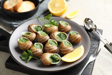 Delicious cooked snails served on light table