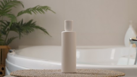 Photo of White bottle of bubble bath on tub indoors