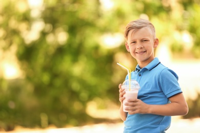 Photo of Little boy with cup of milk shake outdoors