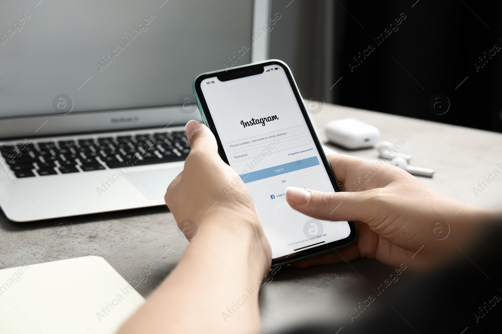 Photo of MYKOLAIV, UKRAINE - JULY 9, 2020: Woman holding Iphone 11 with Instagram app on screen at table, closeup