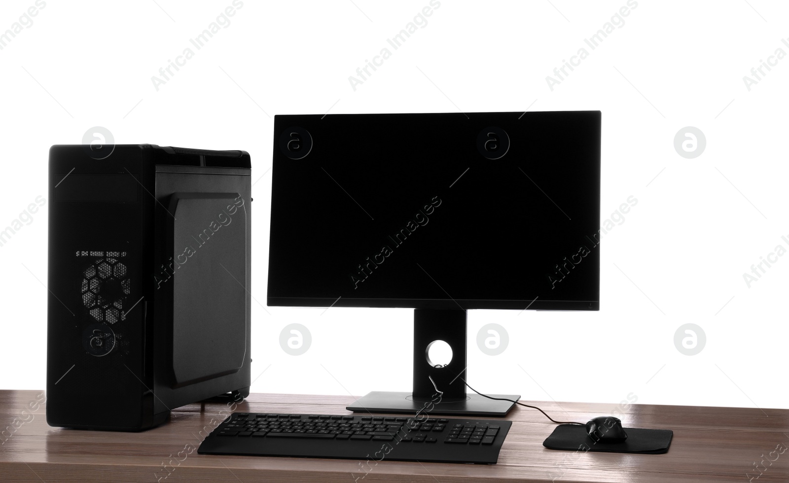 Photo of Modern computer with blank monitor screen and peripherals on wooden table against white background