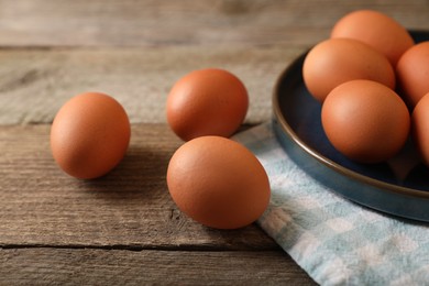 Raw brown chicken eggs on wooden table
