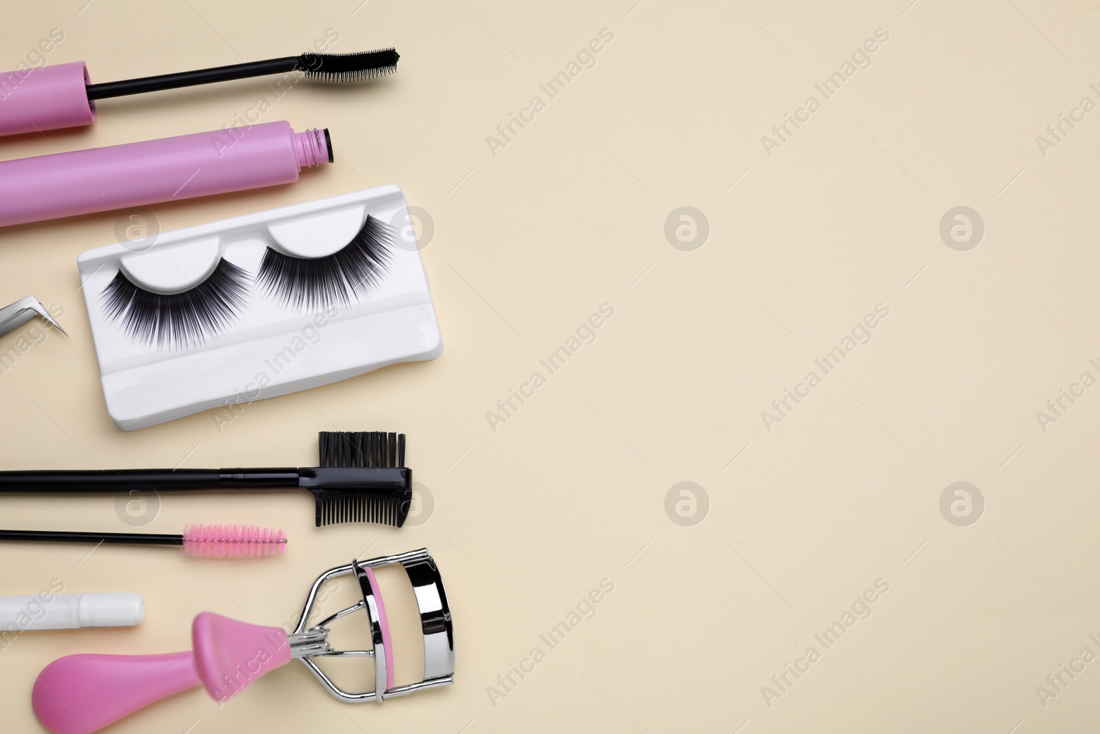 Photo of Flat lay composition with fake eyelashes on beige background, space for text